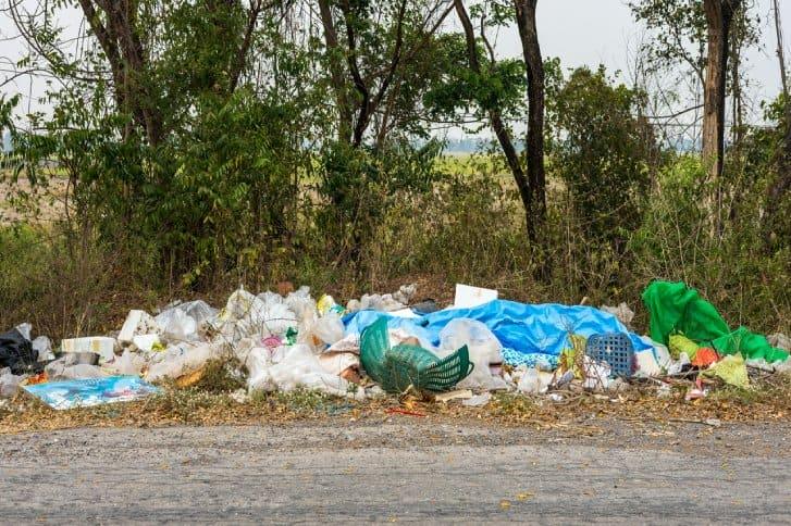 wyrzucone śmieci na poboczu drogi